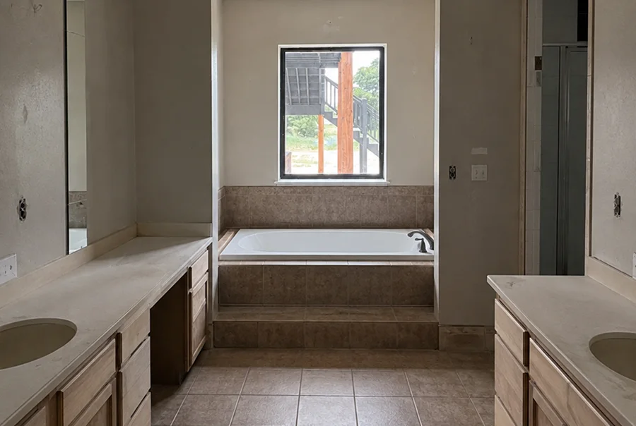 Before photo of primary bathroom with built-in tub and dated tile - Skylar