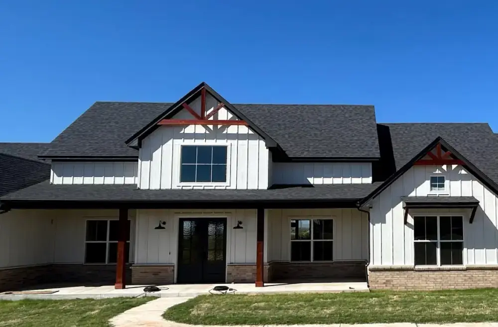Custom home exterior with gabled roof and covered front porch by Skylar Building and Construction
