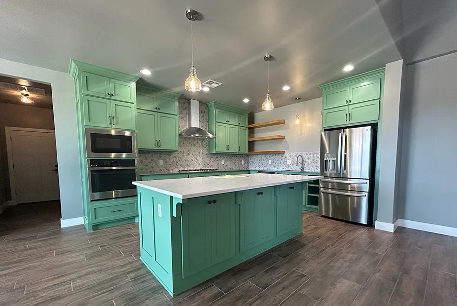 After photo of kitchen remodel with green painted cabinets and white countertops - Skylar